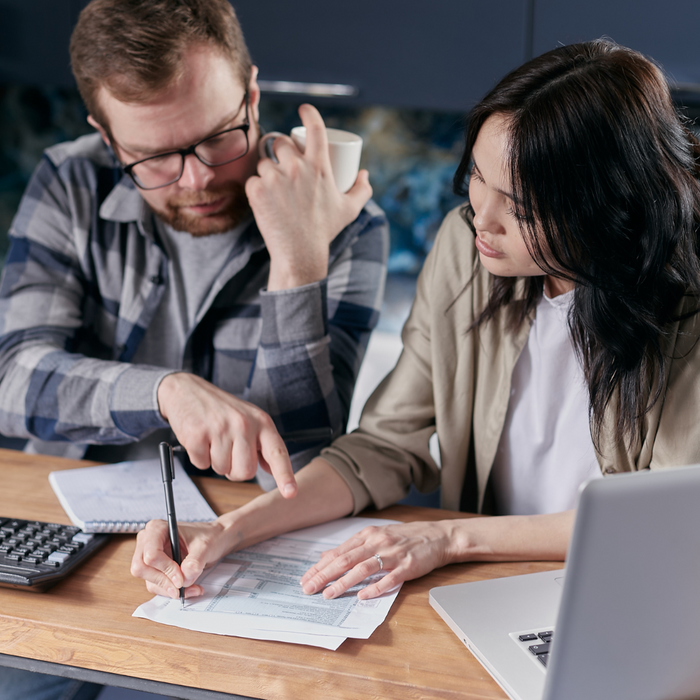 Two homeowners look at their monthly bills and discuss them