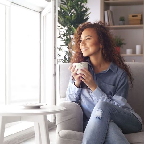 A woman cozy in her home sitting on her couch