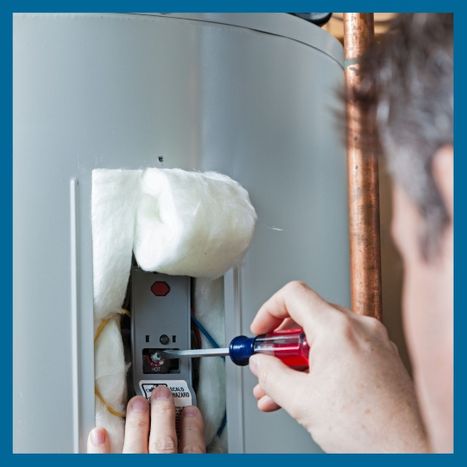 HVAC tech using a screwdriver on a water heater