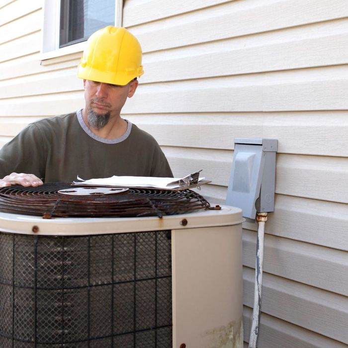 man evaluating an old AC unit
