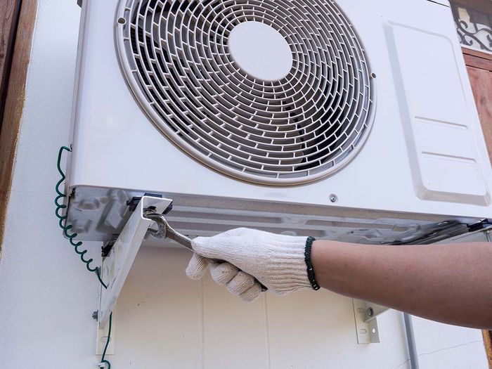 Person making repairs on an AC unit