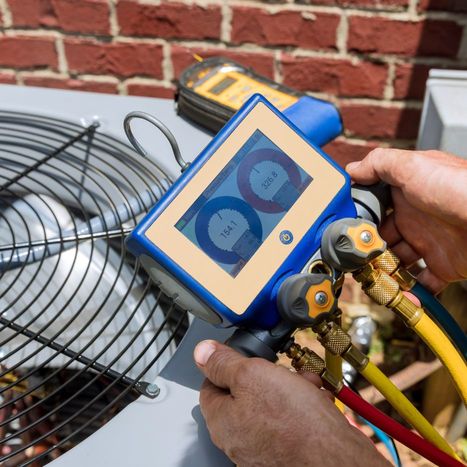 HVAC tech running diagnostics on an air conditioning unit