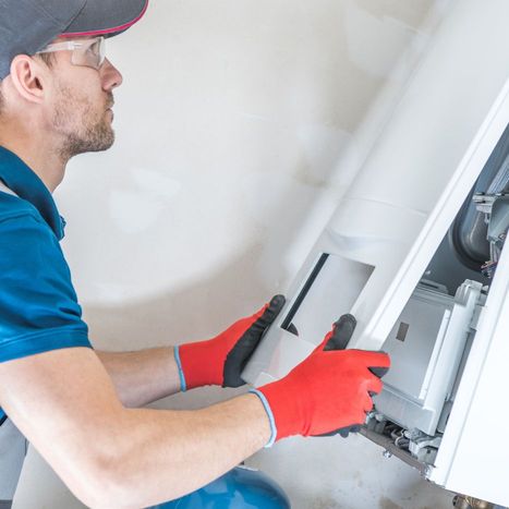 An HVAC technician taking apart a furnace to inspect it. 