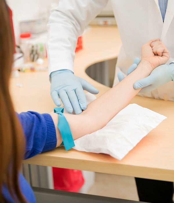 phlebotomist performing blood draw on patient