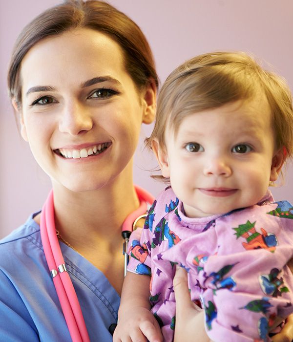 smiling nurse holding a baby