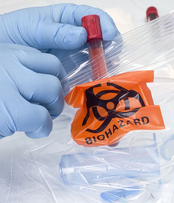 phlebotomist placing blood specimen container into a bag