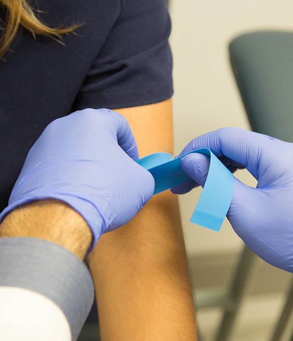 phlebotomist performing blood draw on patient