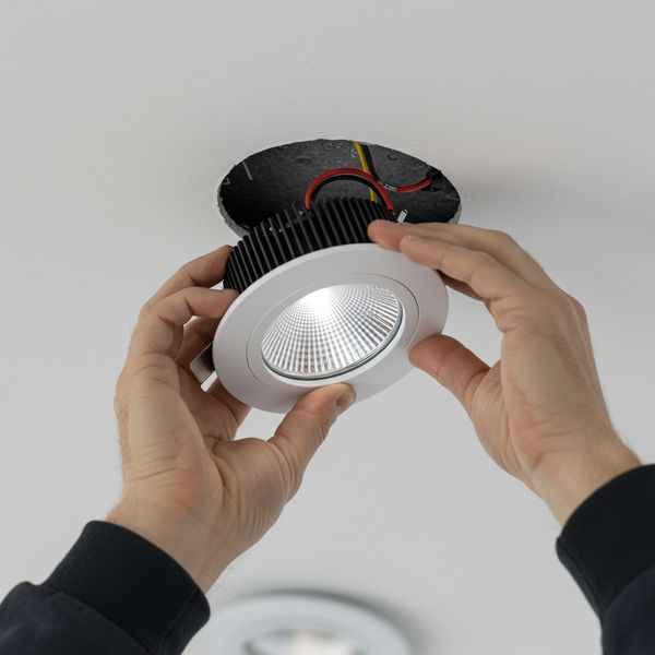 Close-up of modern LED downlight being installed in a clean ceiling