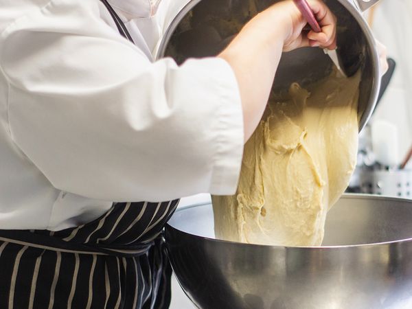 A chef pouring batter into a bowl