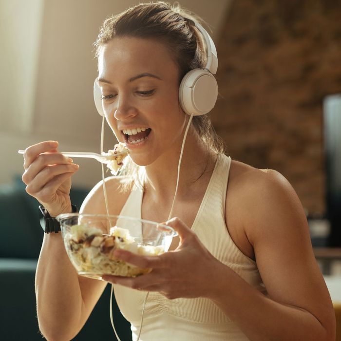Woman in workout gear eating a grain bowl