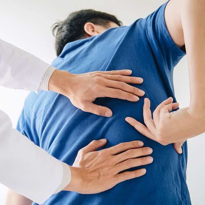 Image of a man showing the chiropractor where his back hurts