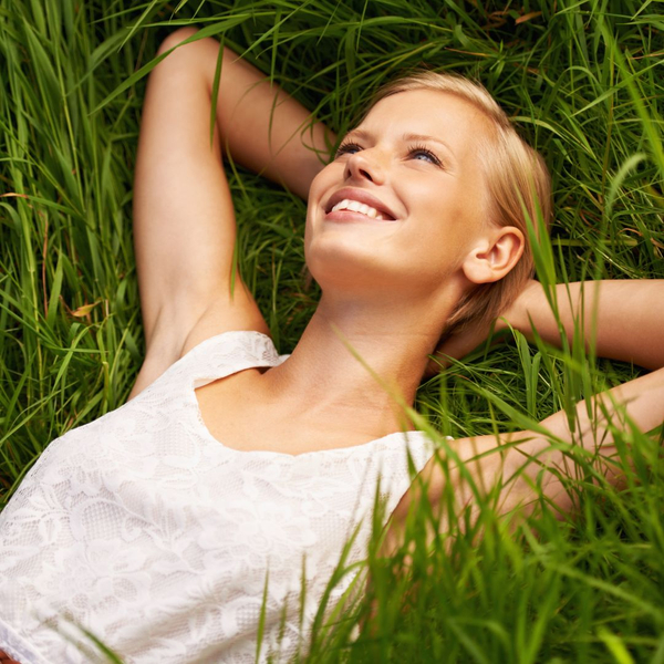 a happy woman lying on the grass