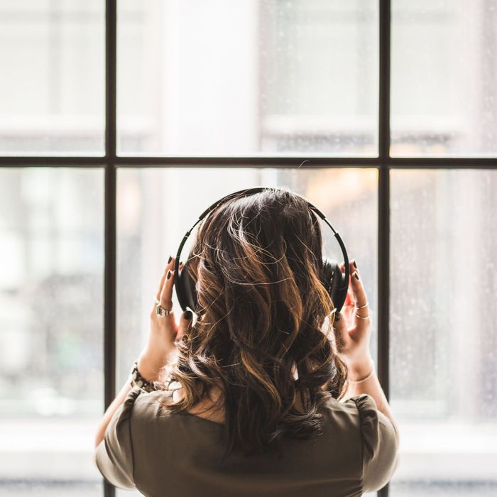 person wearing headphones looking out of window