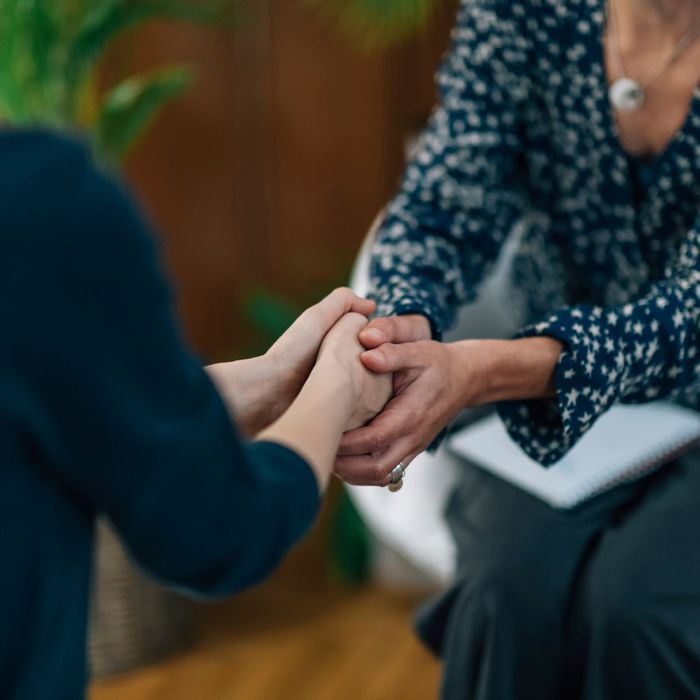 women holding hands comfortingly