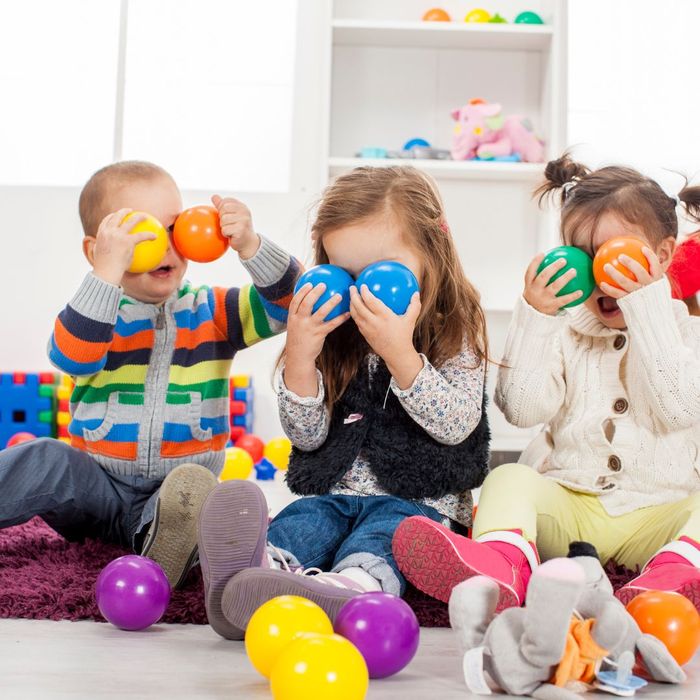 Children holding balls up as eyes 