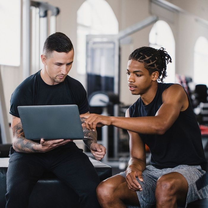 Person trainer and client looking at a laptop