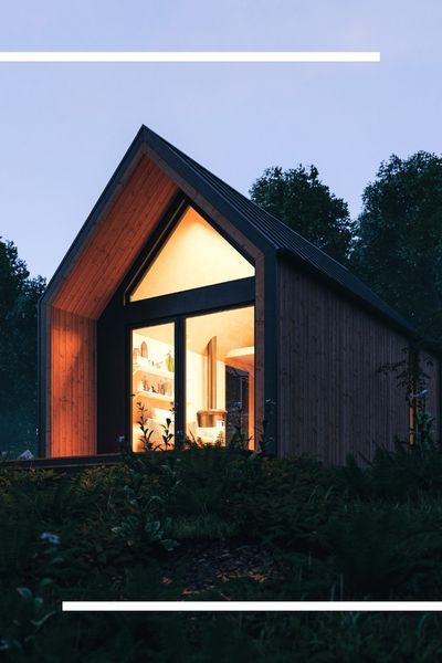 A cinematic evening shot of a modern A-frame guest house with warm interior lighting, large glass windows, and a sleek wood-slat exterior