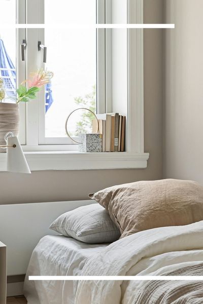 minimalist bedroom corner featuring smooth, professionally finished drywall, a clean white window frame with decorative books on the sill