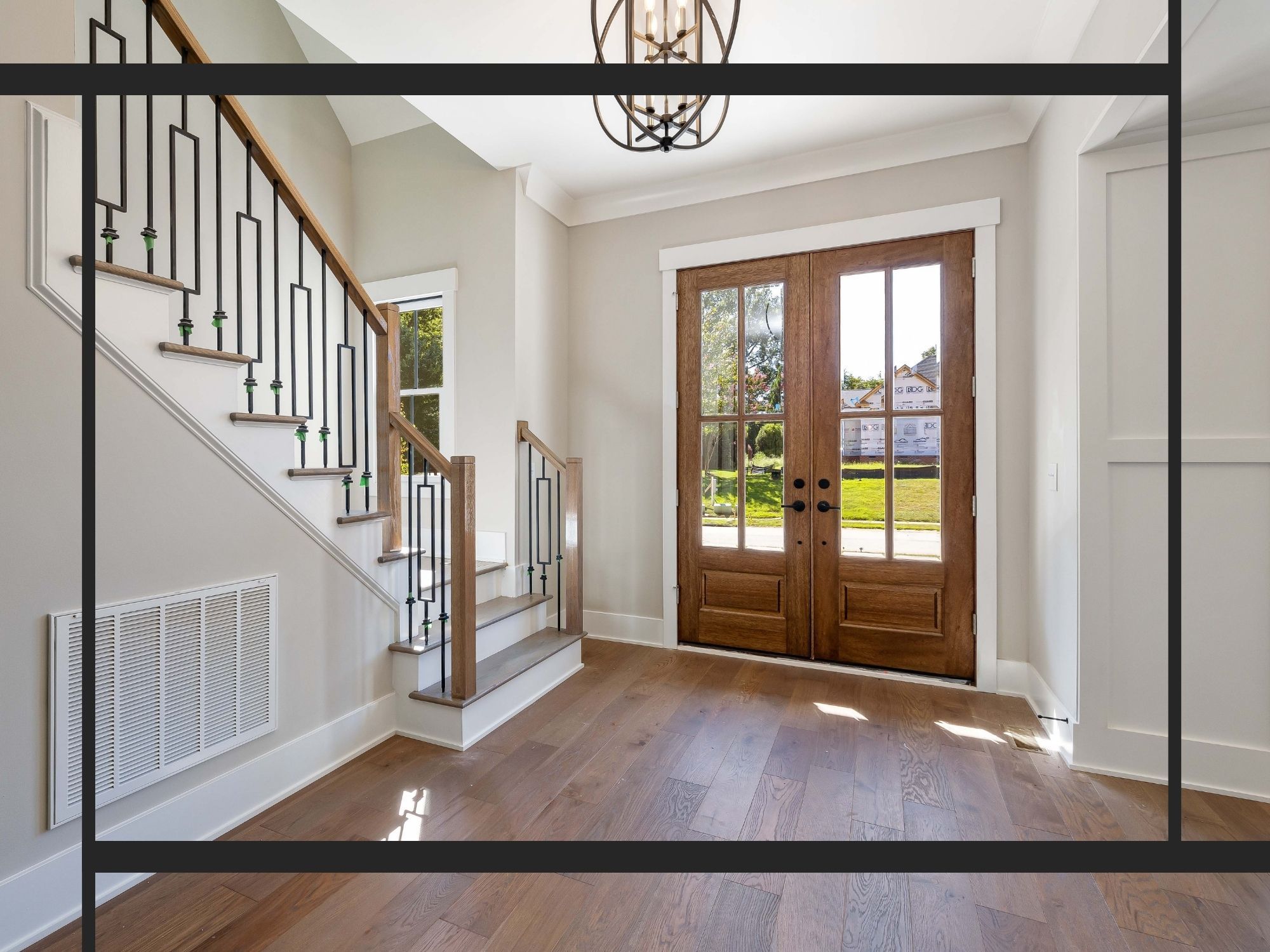 home entryway featuring polished hardwood floors, a white staircase with modern wrought-iron balusters, and elegant double wood-and-glass front doors