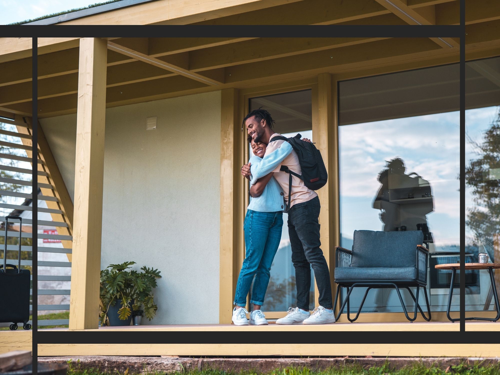 couple hugging on the porch of a modern wooden cabin