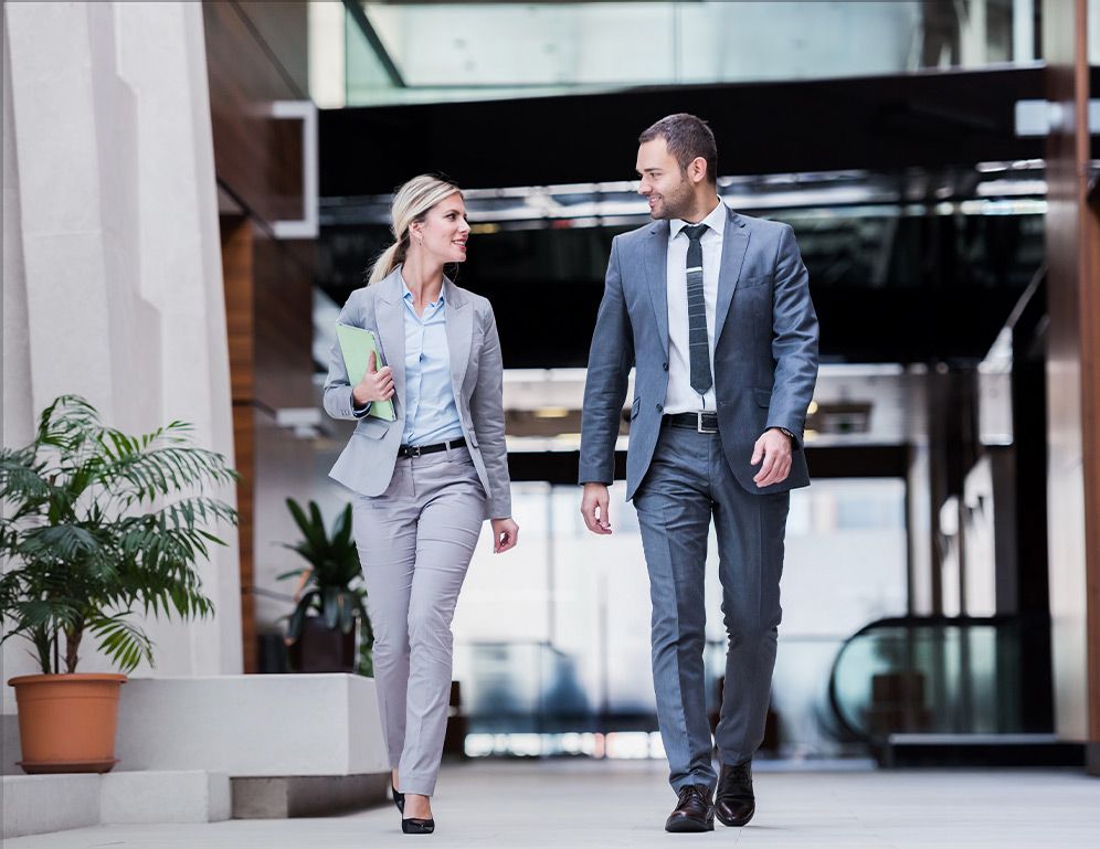 two professionally dressed people walking together