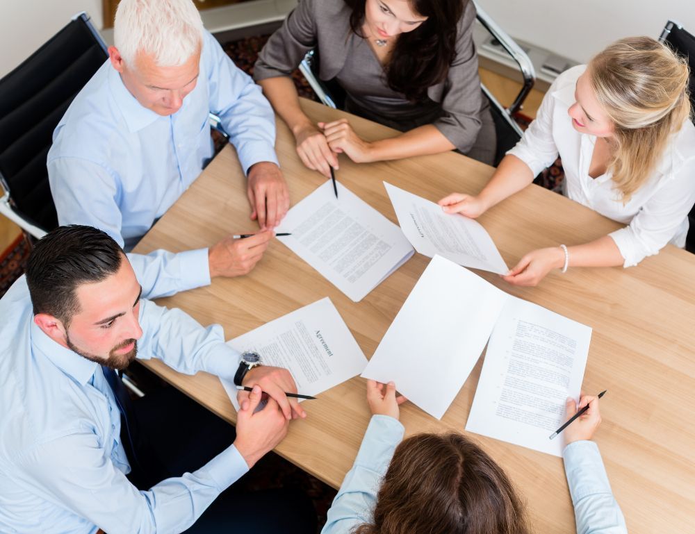 team of professionals sitting around a table in discussion