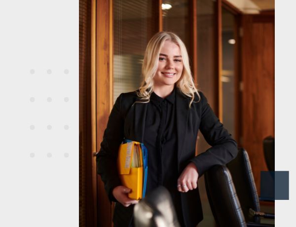 woman standing in a conference room holding file folders