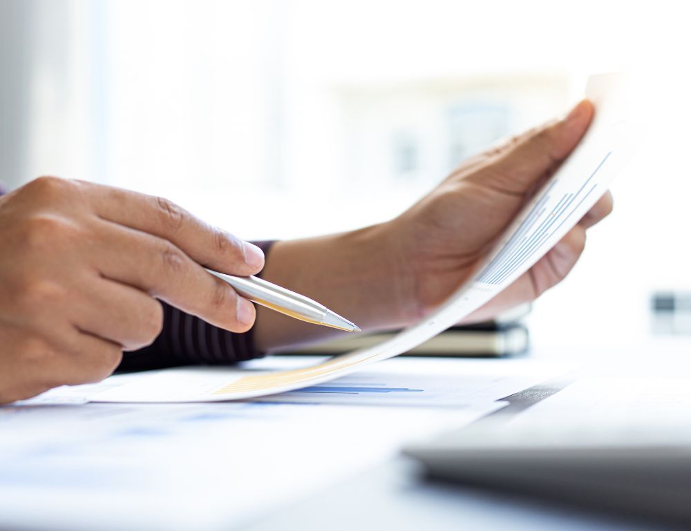 hands holding a piece of paper and a pen