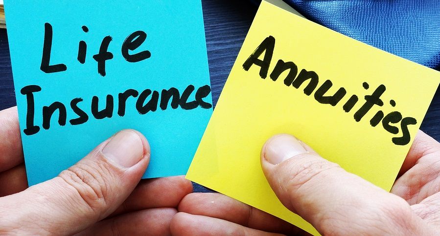 Blue and yellow sticky notes labeled Life Insurance and Annuities held in hands