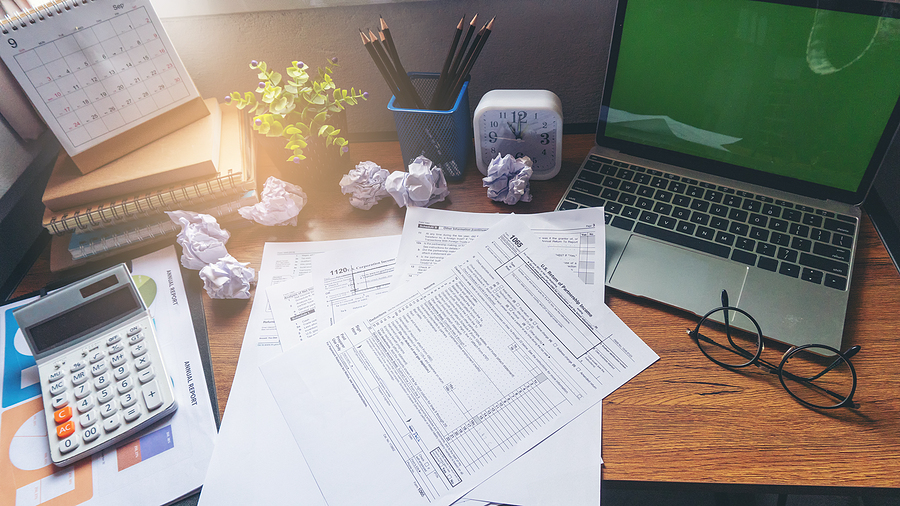 Desk with Tax Forms, Calculator, and Laptop for Tax Planning