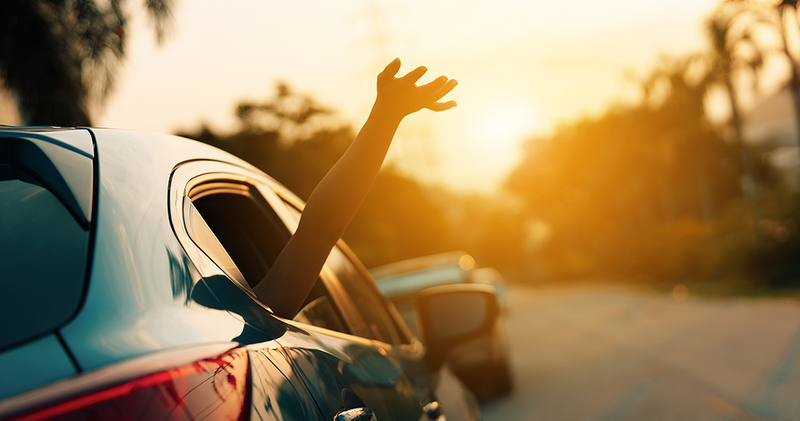 Hand Reaching Out of Car Window on a Sunny Road Trip