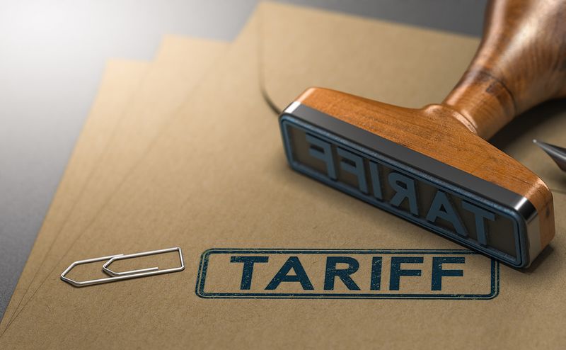 Wooden rubber stamp with the word Tariff pressed on paper, symbolizing trade policy and economic regulation