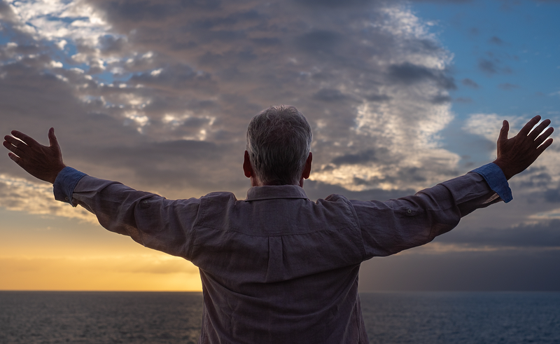 Senior Embracing Sunset Over the Ocean