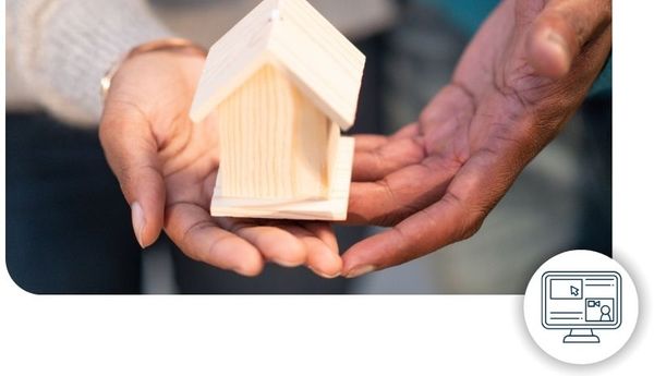 Two people passing a small wooden house from hand to hand