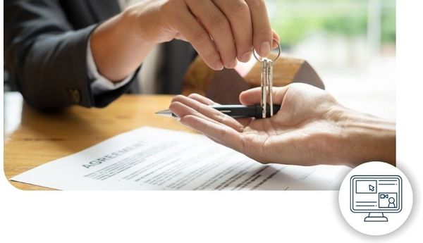 A real estate agent hands keys over to a home buyer