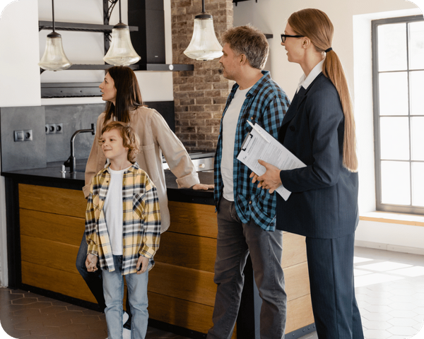 family stands in kitchen with realtor looking at house Douglas County 3 (1).png