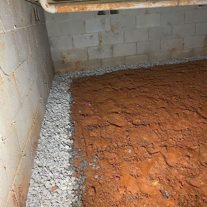 Interior drainage trench backfilled with gravel along foundation wall