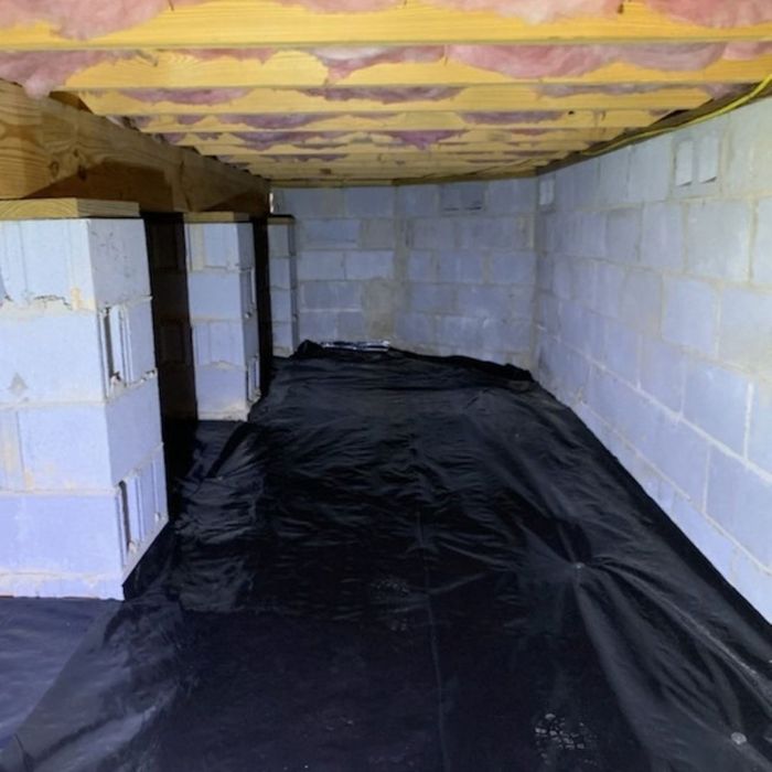 Clean encapsulated crawl space with black floor vapor barrier and sealed walls