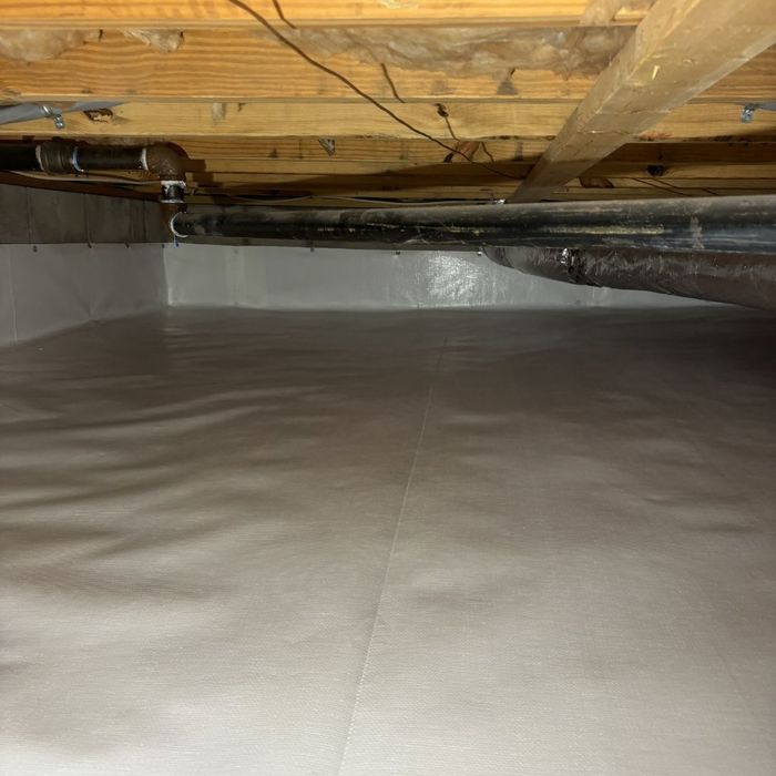 Detailed view of a seamlessly sealed vapor barrier edge protecting a foundation wall from pests and water.