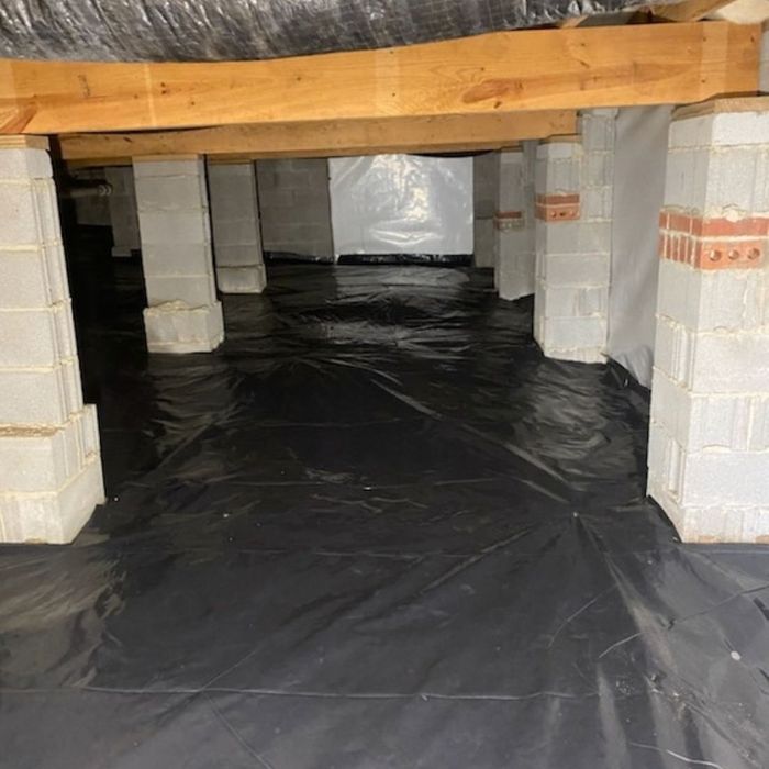 Black vapor barrier installed on crawl space floor and foundation piers