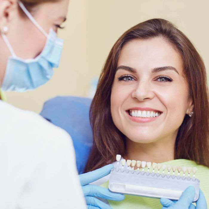 person smiling while looking at dental implants