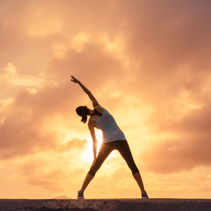 woman stretching at sunset