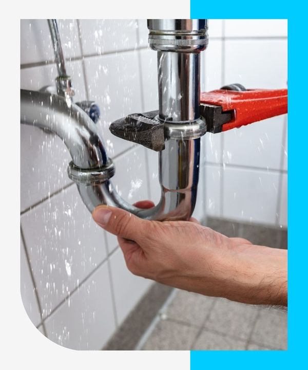 plumber using wrench to repair leaking pipe