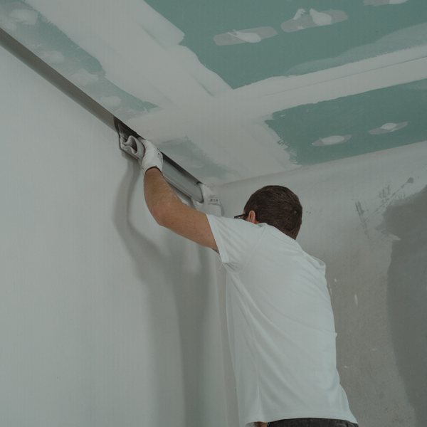 A person completing a drywall job