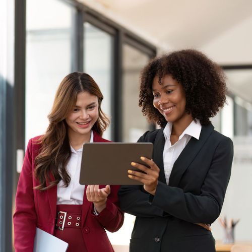 two employees speaking and looking at tablet two employees speaking and looking at tablet
