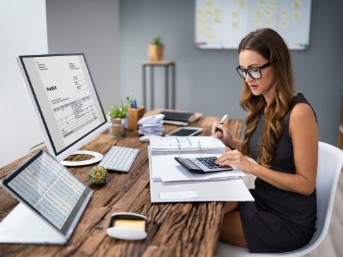 woman sits in front of computer with statements while using a calculator Tallahassee 1.jpg