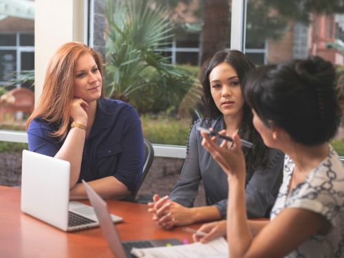 3 businesswomen sit discussing at table Tallahassee 2.jpg