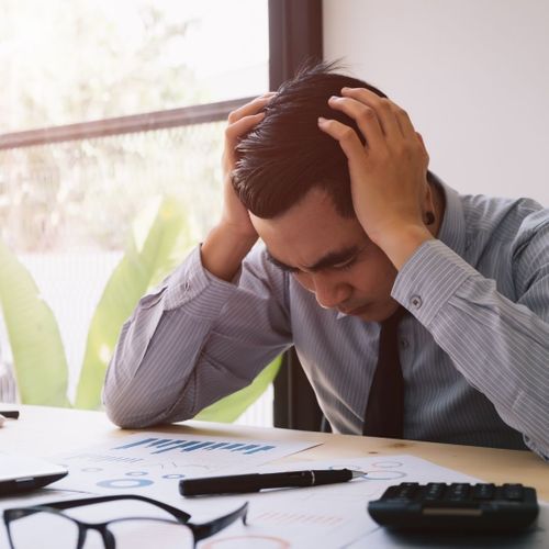 stressed business man looking through books