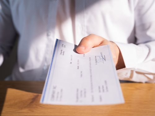 person holds out a printed business check Thomasville 3.jpg