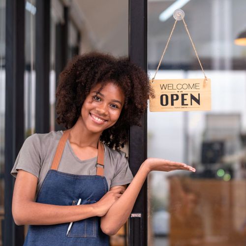 business owner smiling with open sign